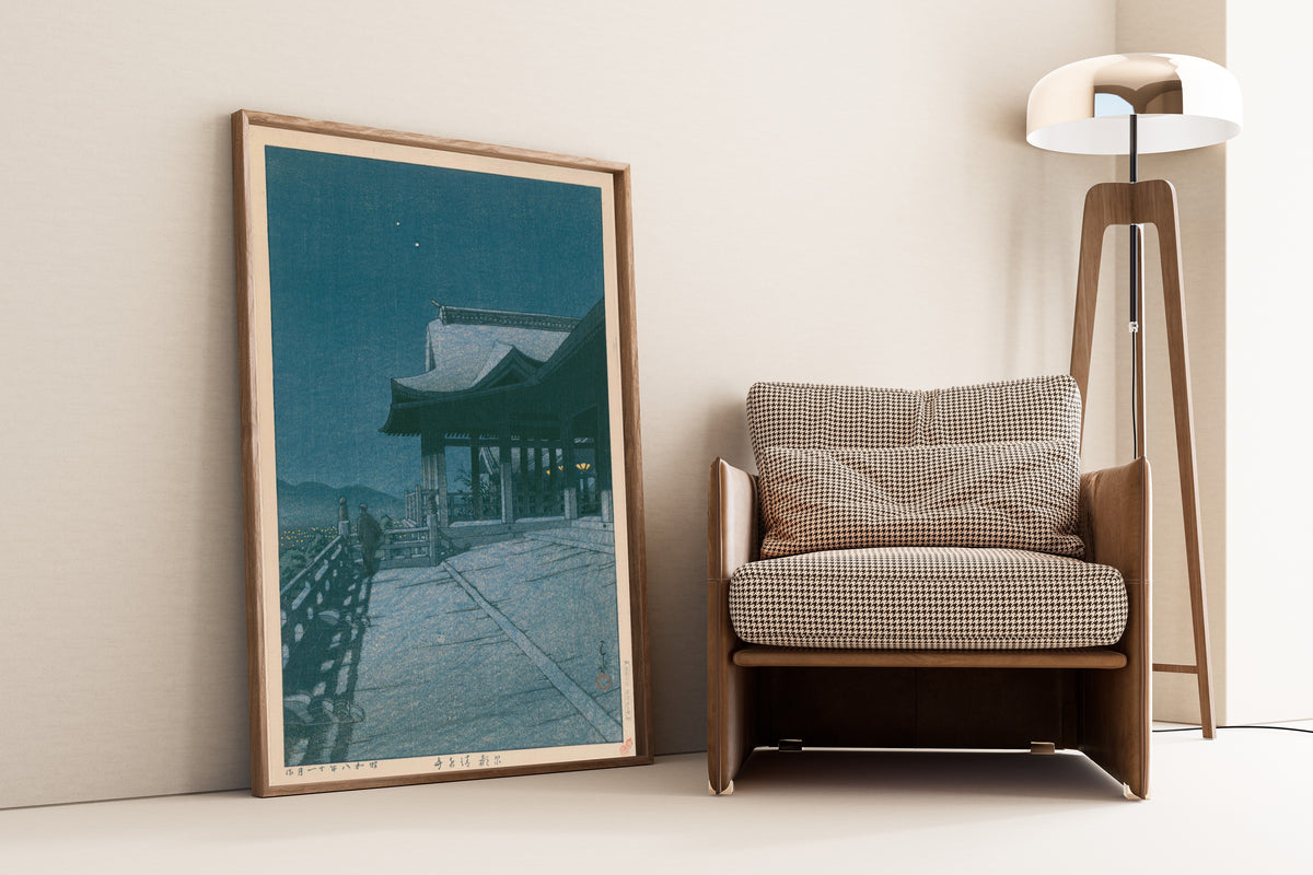 Framed art print of Kiyomizu Temple, Kyoto by Kawase Hasui, leaning against a wall beside an armchair and a floor lamp