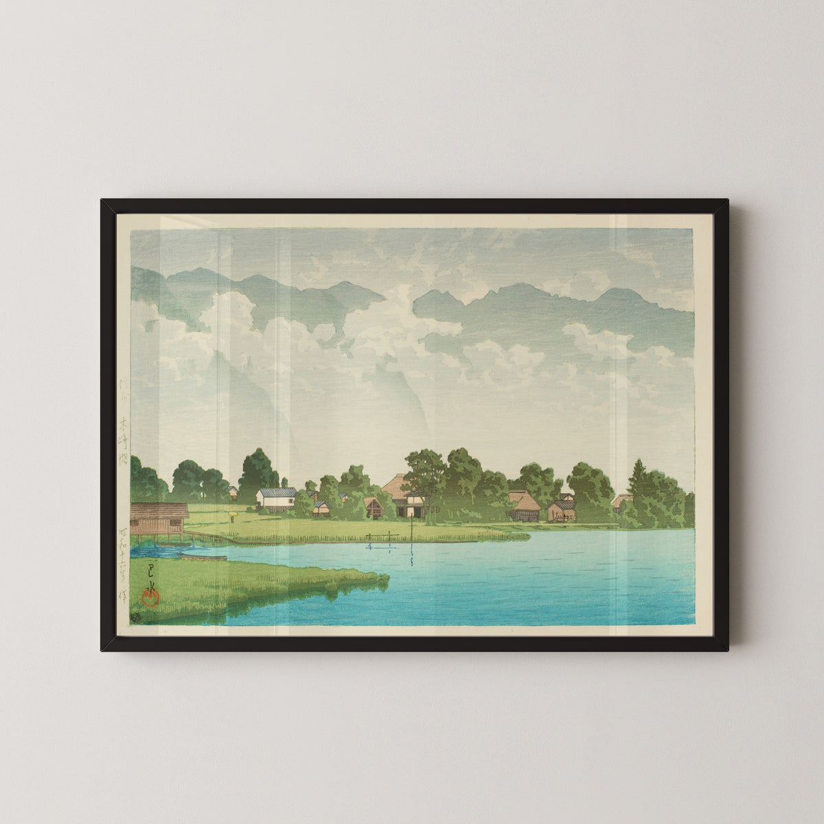 Framed art print of Kizaki Lake in Shinshu by Kawase Hasui, in a black frame on a pale wall