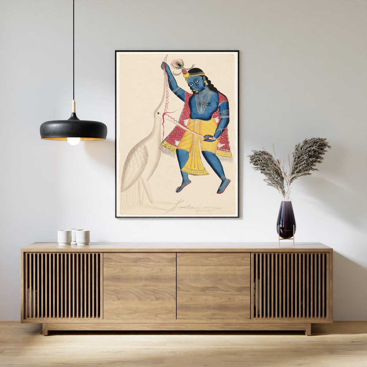 Framed art print of Krishna Killing Bakasura by Kalighat painter, above a slatted wood sideboard