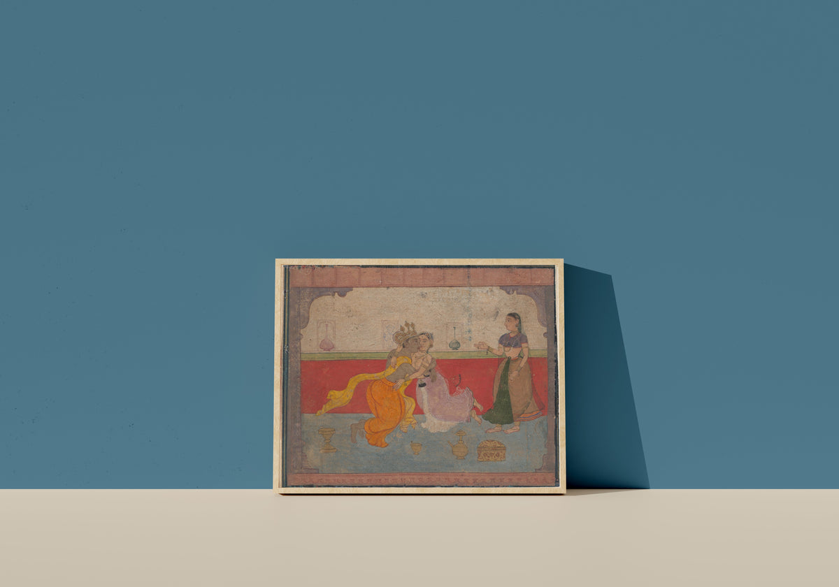 Framed art print of Krishna Kisses Radha: Page from the Boston Rasikapriya (Lover's Breviary) by Amber school, in a light wood frame leaning on a blue wall