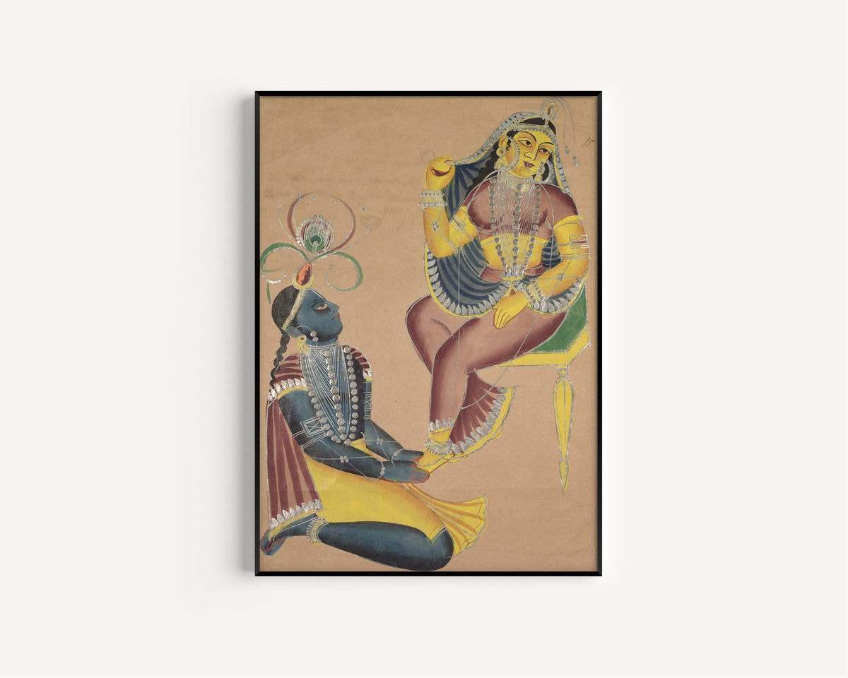 Framed art print of Krishna Stroking Radha's Feet by Kalighat painter, in a slim black frame on a plain white wall