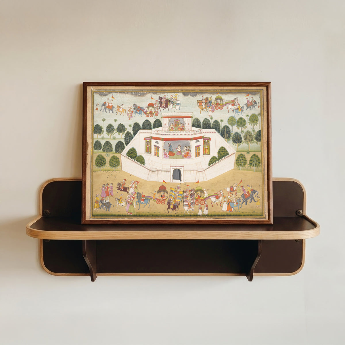 Framed art print of Krishna and Balarama within a Walled Palace by Bikaner school, in a dark wood frame resting on a wall shelf