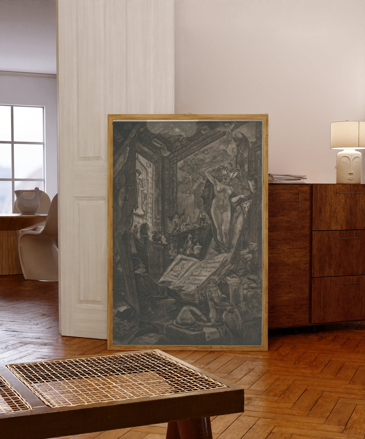 Framed art print of L'incantation (2nd state) by Félicien Rops, in a light wood frame leaning in a warm room with a parquet floor