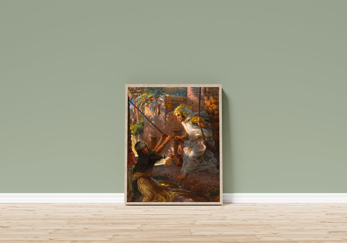 Framed art print of La Balançoire by Étienne Dinet, in a light wood frame leaning on a sage green wall above a wooden floor