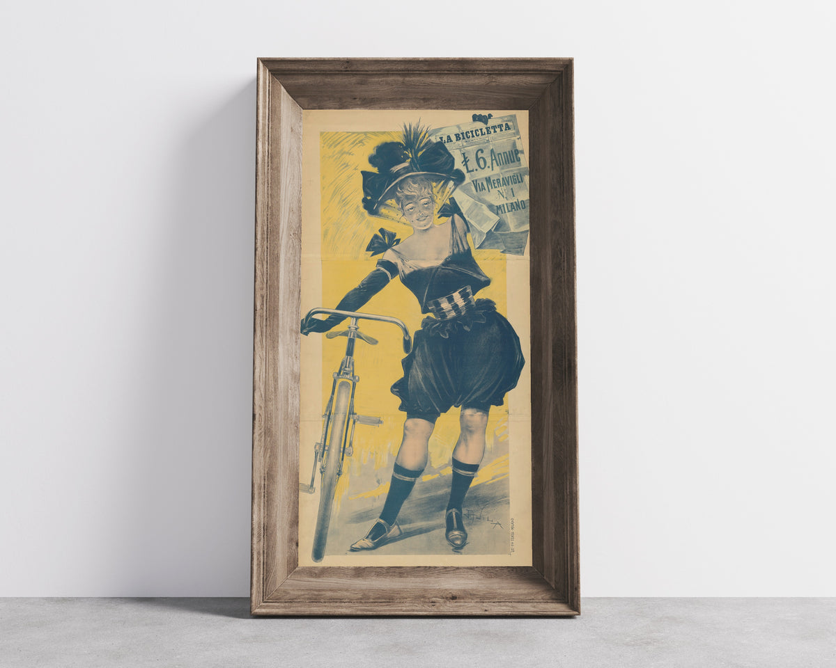Framed art print of La Bicicletta by Aleardo Villa, in a wide wooden frame leaning against a concrete wall