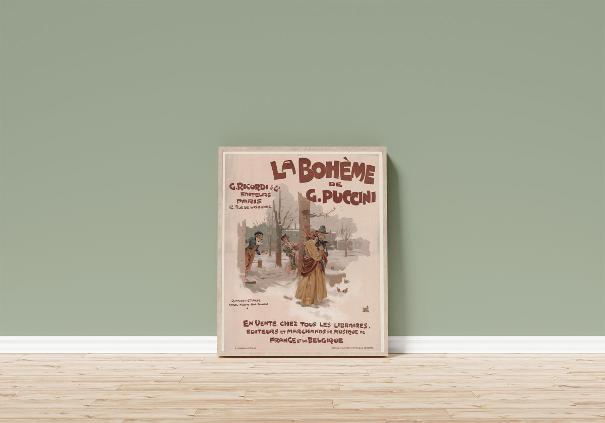 Framed art print of La Bohème de G. Puccini by Adolfo Hohenstein, in a light wood frame leaning on a sage green wall above a wooden floor