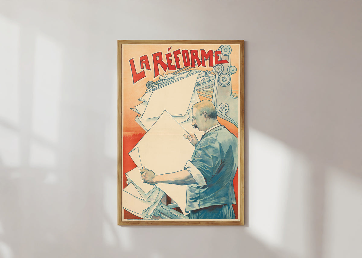 Framed art print of La Réforme by Henri Privat-Livemont, in a light wood frame on a sunlit white wall