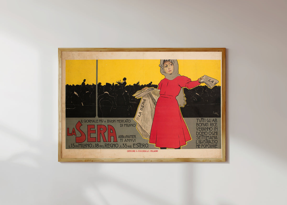 Framed art print of La Sera by Leopoldo Metlicovitz, in a light wood frame on a sunlit white wall