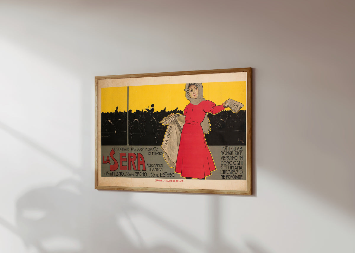 Framed art print of La Sera by Leopoldo Metlicovitz, in a light wood frame on a sunlit white wall, seen at a slight angle