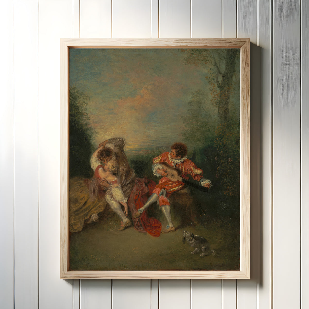 Framed art print of La Surprise by Jean-Antoine Watteau, in a light wood frame on a white panelled wall
