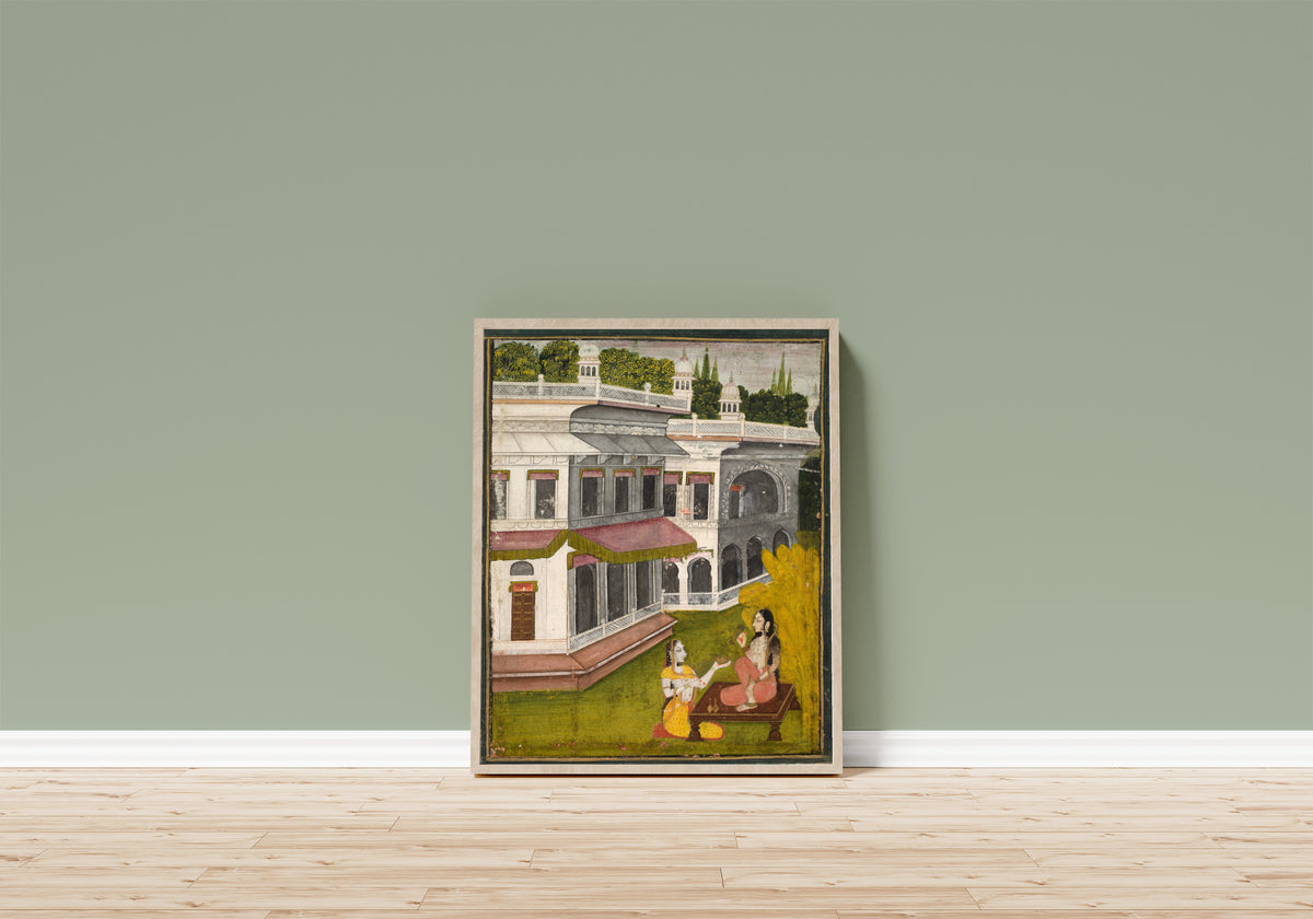 Framed art print of Lady and Her Confidante by Kishangarh school, in a light wood frame leaning on a sage green wall above a wooden floor