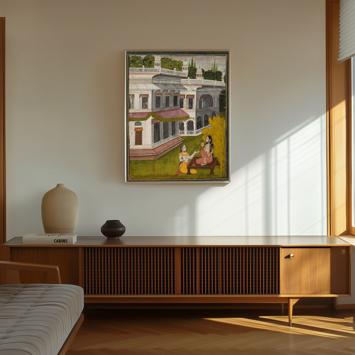 Framed art print of Lady and Her Confidante by Kishangarh school, in a thin light frame on a sunlit wall above a wooden sideboard