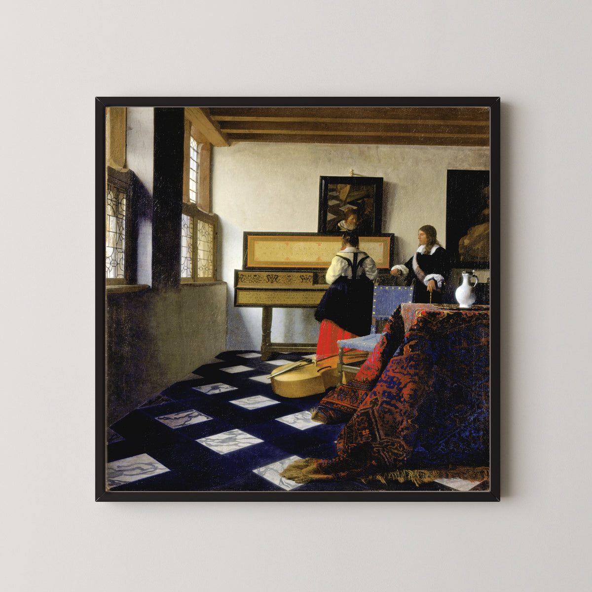 Framed art print of Lady at the Virginal with a Gentleman, ‘The Music Lesson’ by Johannes Vermeer, in a black frame on a pale wall