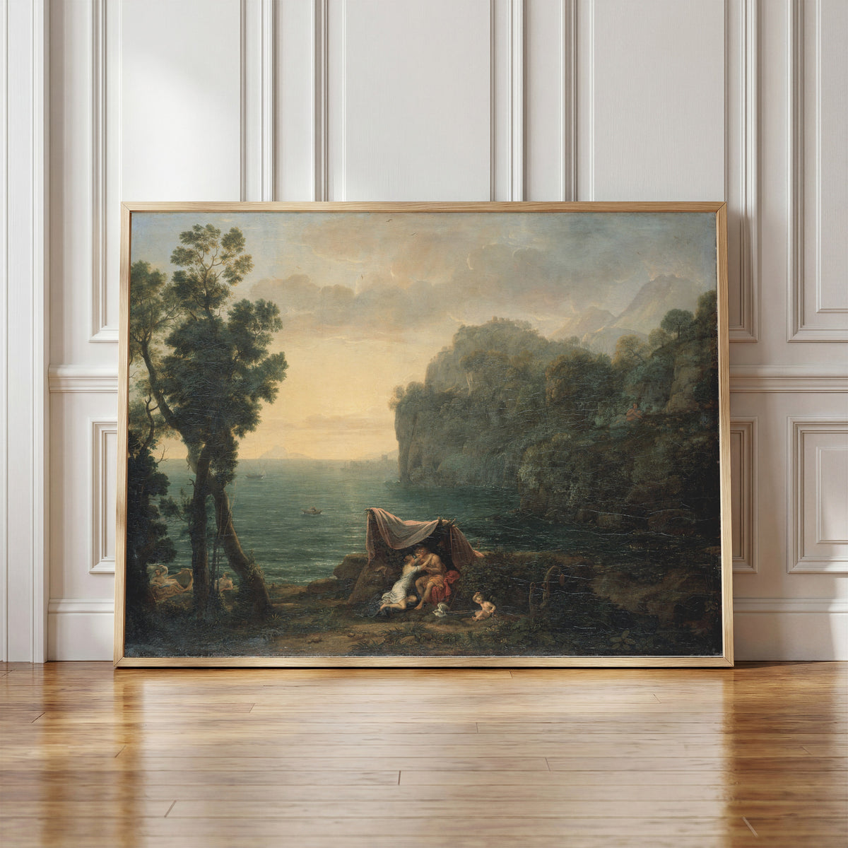Framed art print of Landscape with Acis and Galatea by Claude Lorrain, in a light wood frame leaning against a panelled white wall