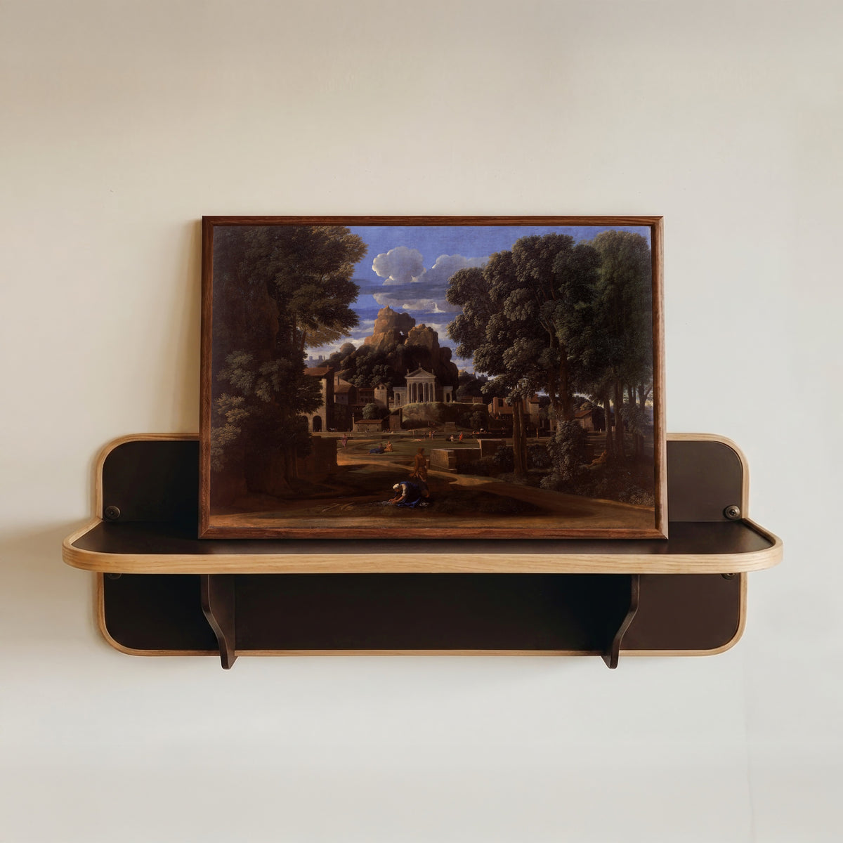 Framed art print of Landscape with the Ashes of Phocion by Nicolas Poussin, in a dark wood frame resting on a wall shelf