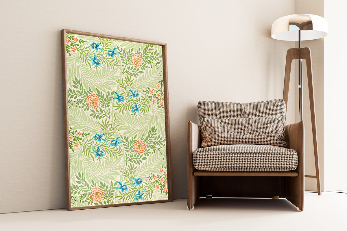 Framed art print of Larkspur by William Morris, leaning against a wall beside an armchair and a floor lamp