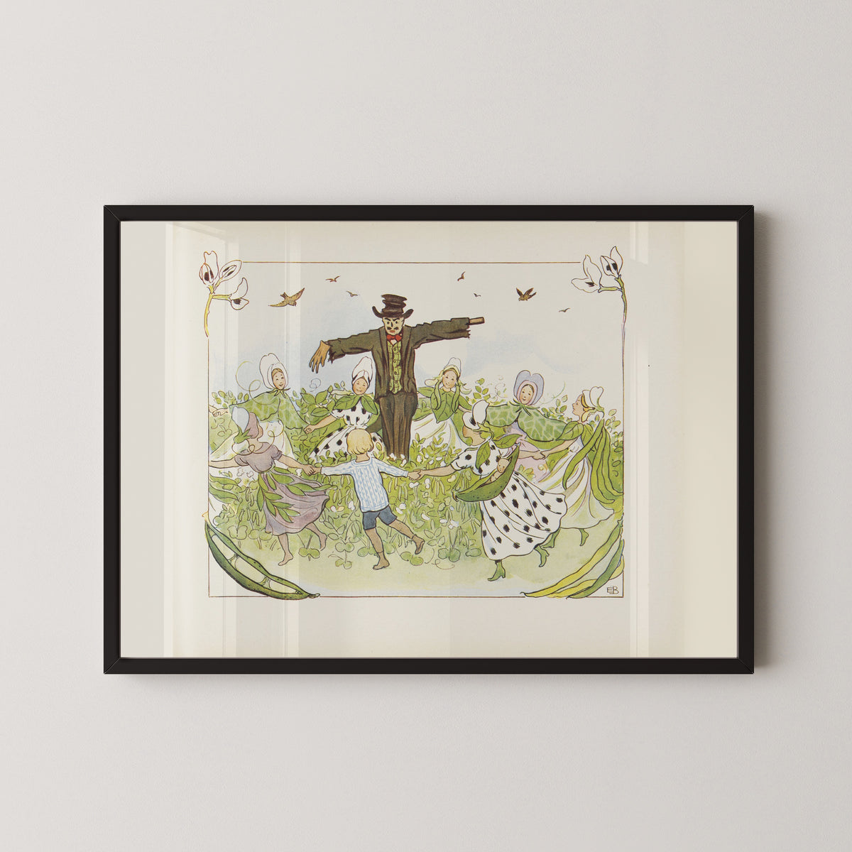 Framed art print of Lasse in the Ring Dance round the Scarecrow by Elsa Beskow, in a black frame on a pale wall