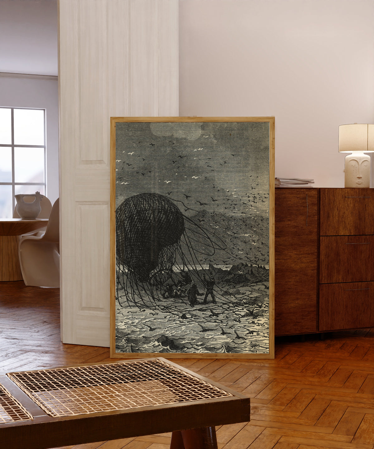 Framed art print of Le ballon retombait définitivement sur le sable (The… by Jules Férat, in a light wood frame leaning in a warm room with a parquet floor