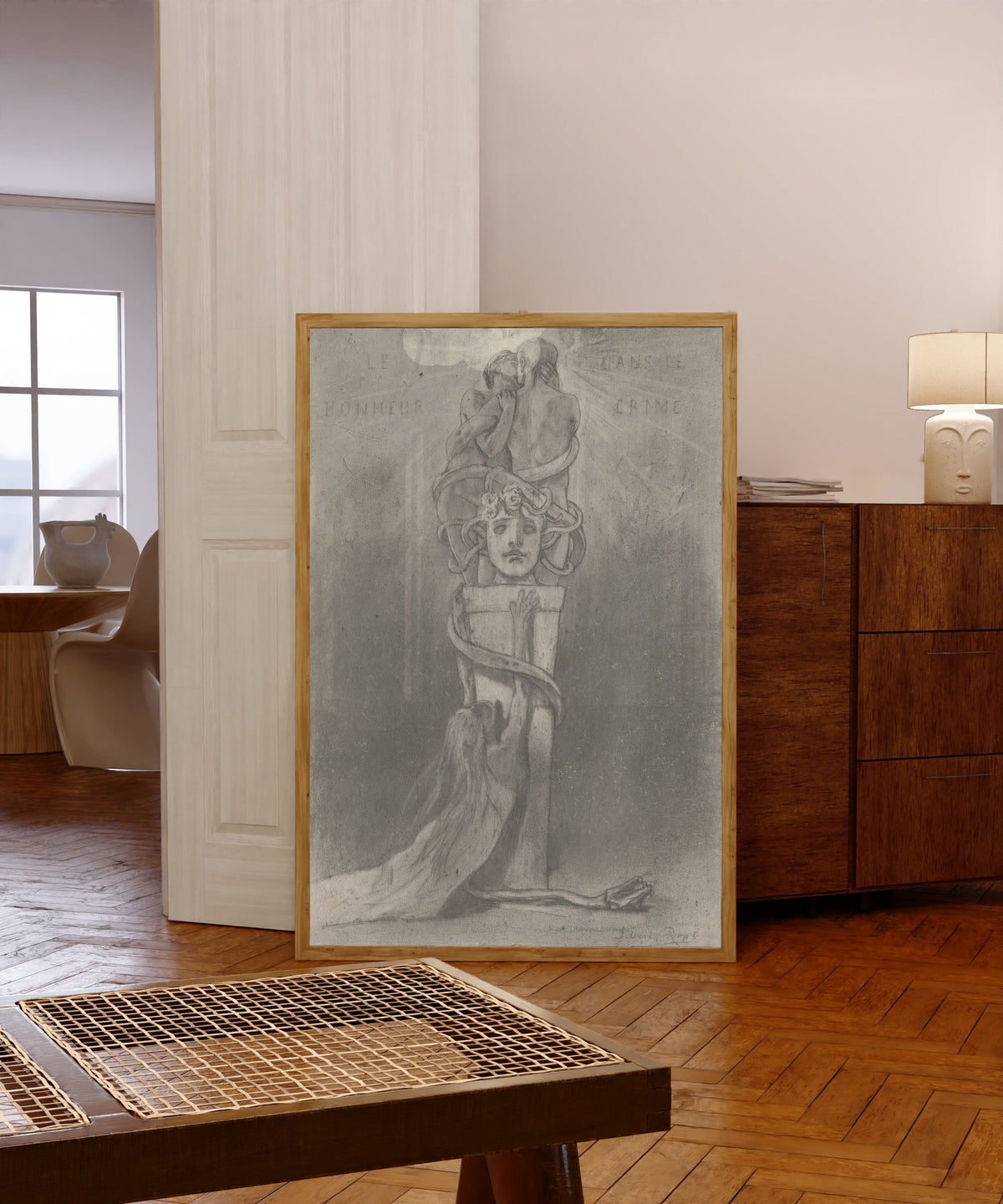 Framed art print of Le bonheur dans le crime (2nd state) by Félicien Rops, in a light wood frame leaning in a warm room with a parquet floor