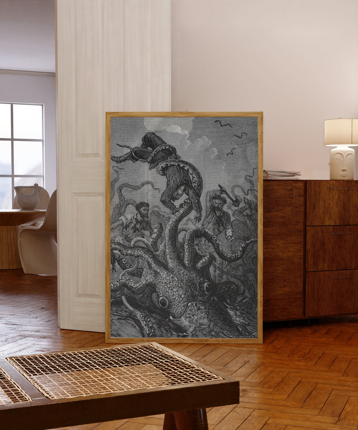 Framed art print of Le poulpe brandissait la victime comme une… by Alphonse de Neuville, in a light wood frame leaning in a warm room with a parquet floor