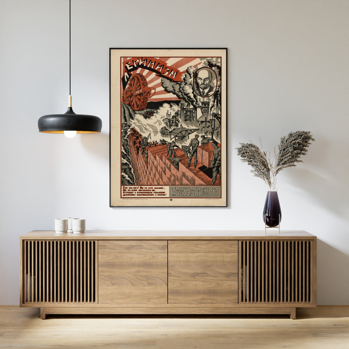 Framed art print of Leninism, above a slatted wood sideboard