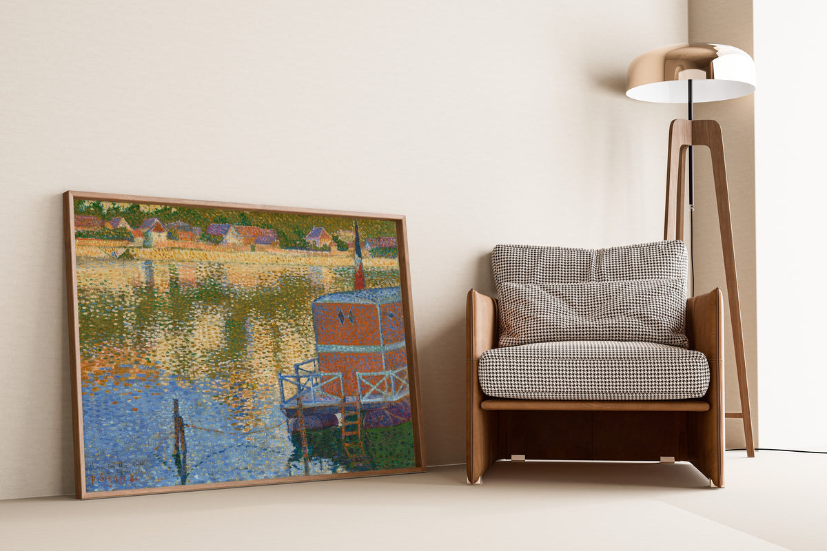 Framed art print of Les Andelys, The Baths by Paul Signac, leaning against a wall beside an armchair and a floor lamp