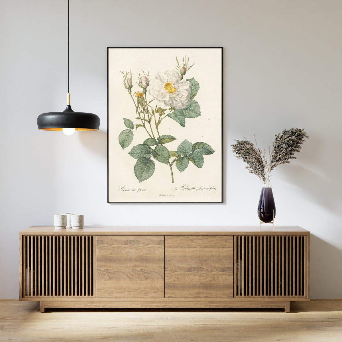 Framed art print of Les Roses: Rosa Alba foliacea by Pierre-Joseph Redouté, above a slatted wood sideboard