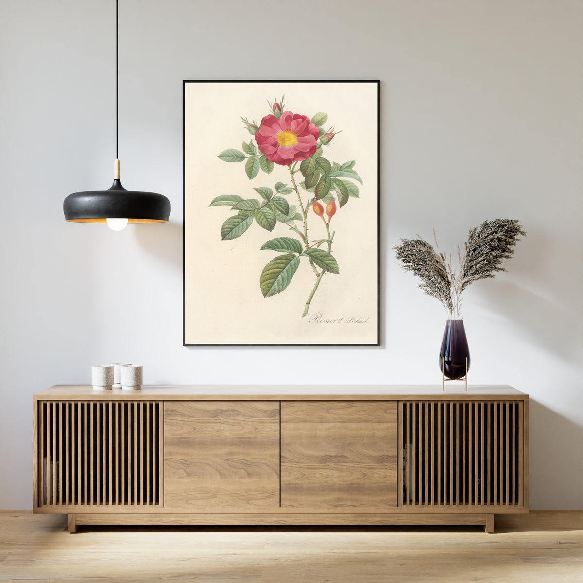 Framed art print of Les Roses: Rosa Damascena Coccinea by Pierre-Joseph Redouté, above a slatted wood sideboard