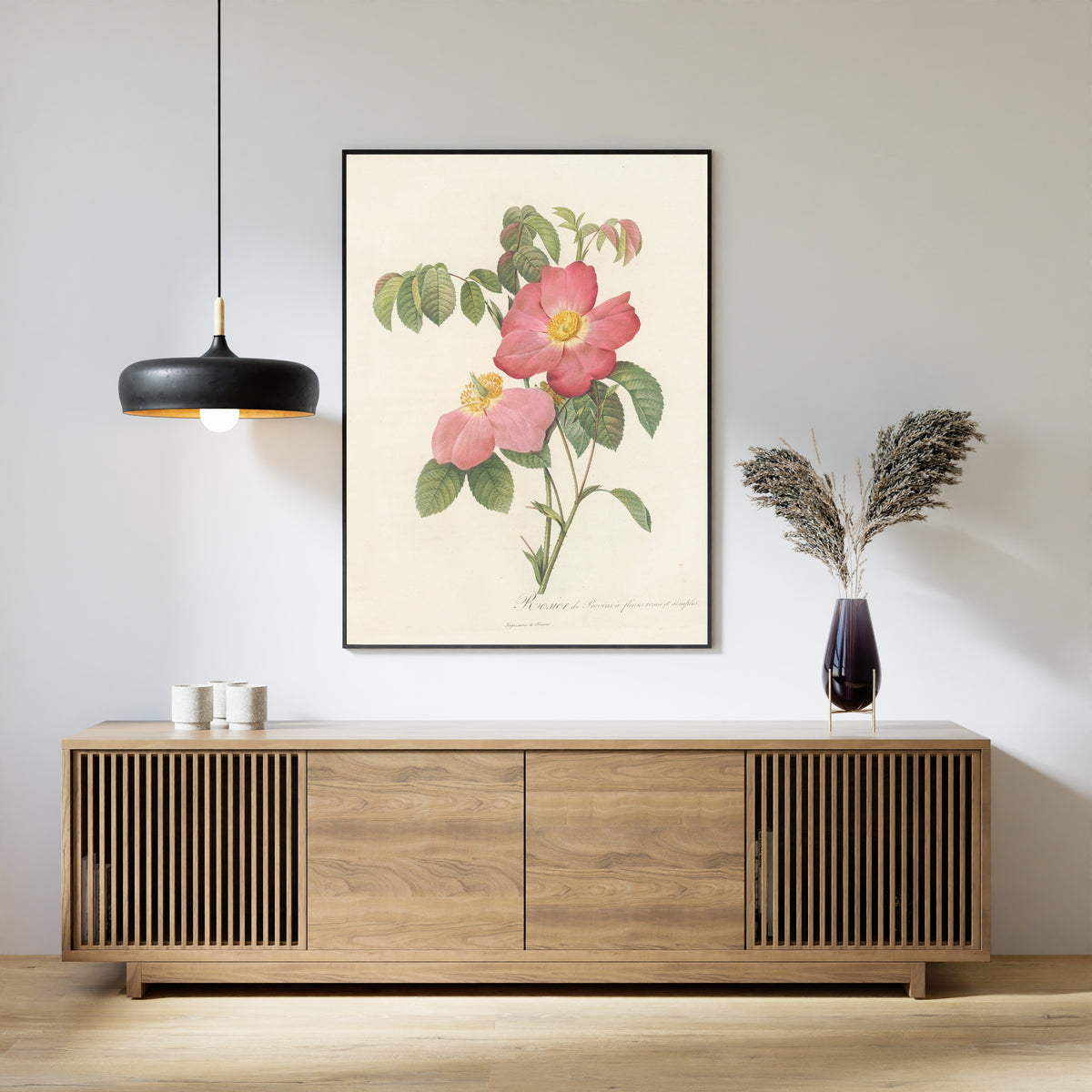 Framed art print of Les Roses: Rosa Gallica Rosea Flore Simplici by Pierre-Joseph Redouté, above a slatted wood sideboard