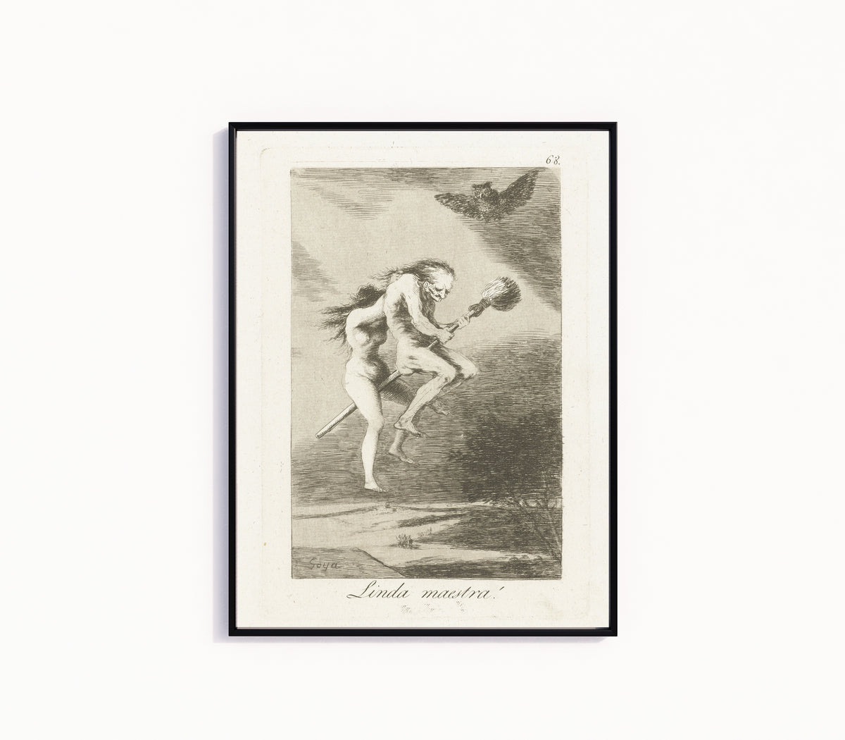 Framed art print of Linda maestra! (A Fine Teacher), Los Caprichos, Plate 68 by Francisco de Goya, in a slim black frame on a plain white wall