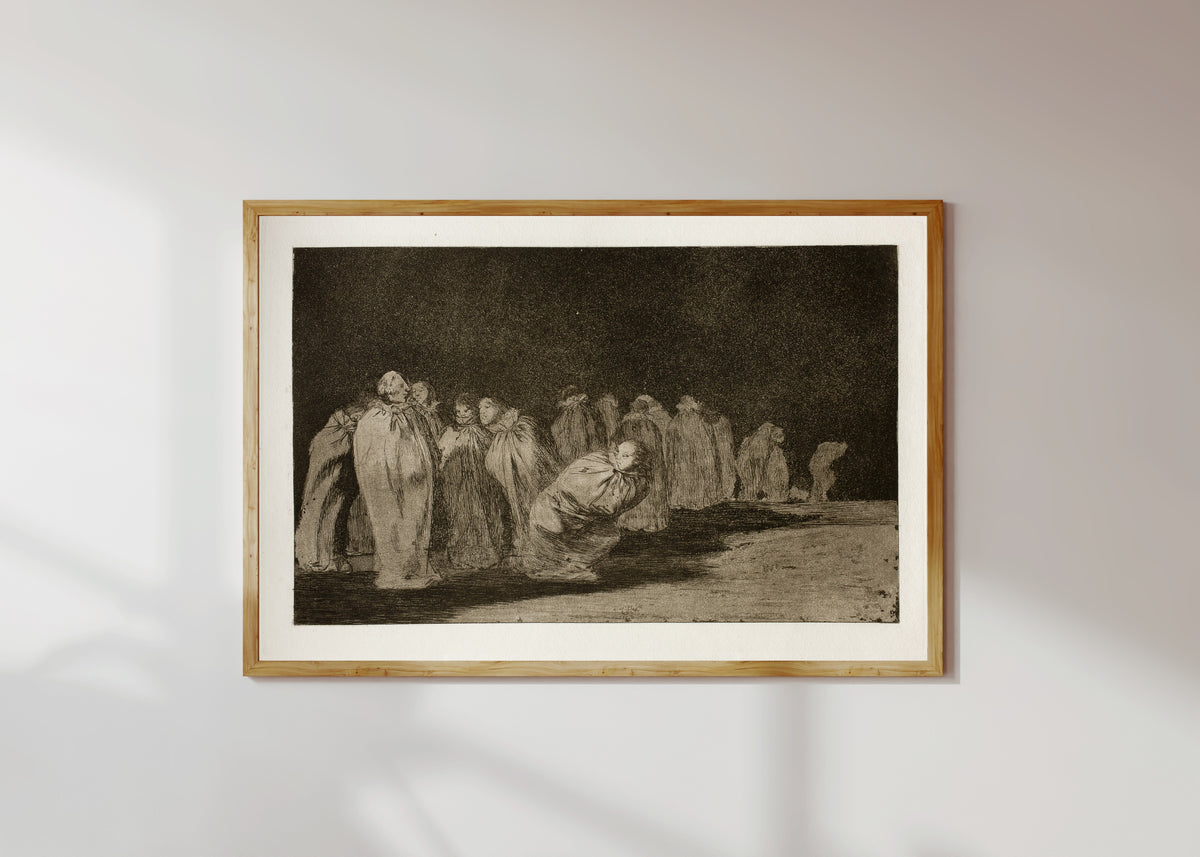 Framed art print of Los ensacados (The Men in Sacks), from Los Disparates by Francisco de Goya, in a light wood frame on a sunlit white wall