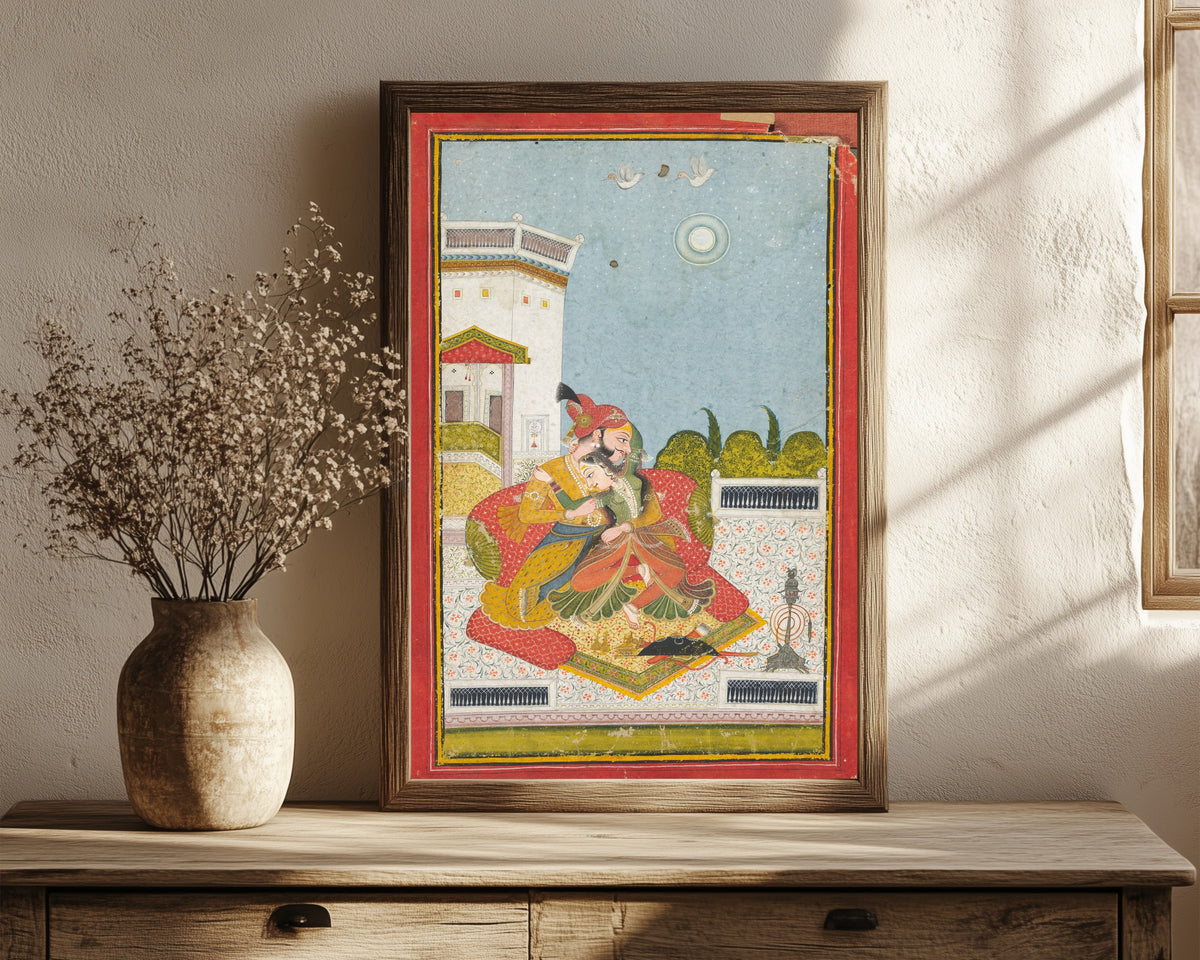 Framed art print of Lovers Embracing (Raga Malkaus) by Bundi school, in a dark wood frame leaning on a rustic console beside dried flowers