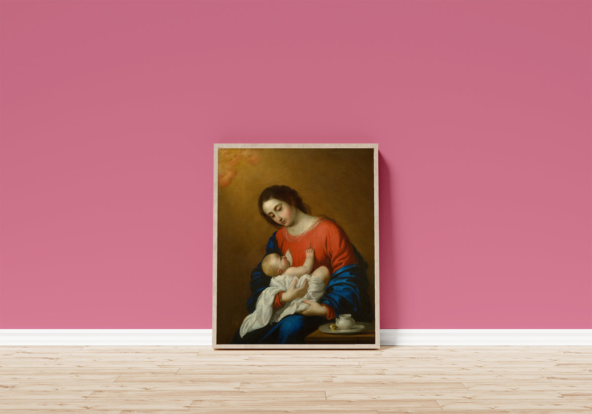 Framed art print of Madonna and Child by Francisco de Zurbarán, in a light wood frame leaning on a pink wall above a wooden floor