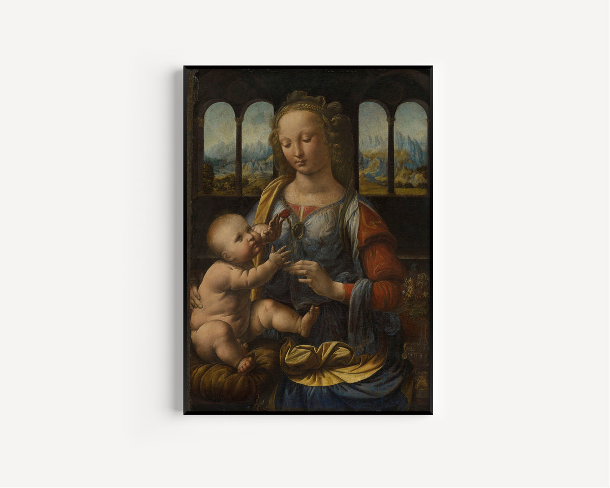 Framed art print of Madonna of the Carnation by Leonardo da Vinci, in a slim black frame on a plain white wall