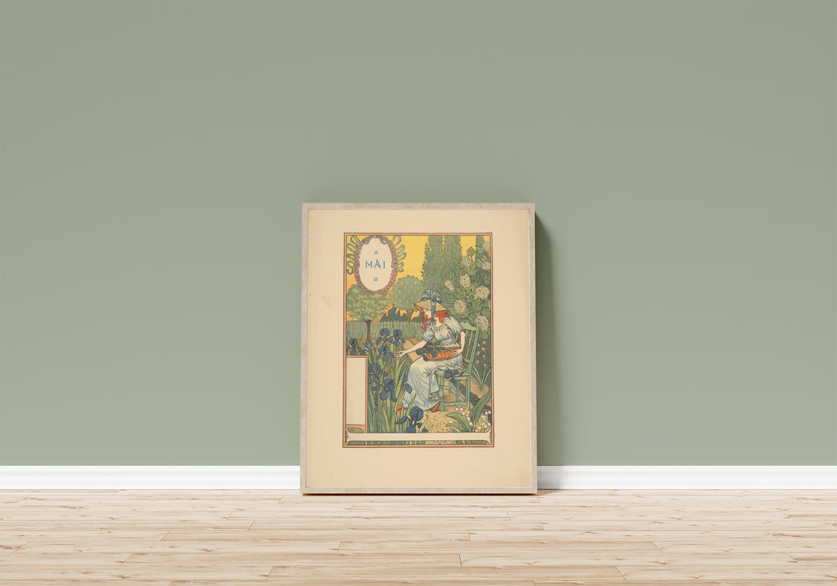 Framed art print of Mai by Eugène Grasset, in a light wood frame leaning on a sage green wall above a wooden floor
