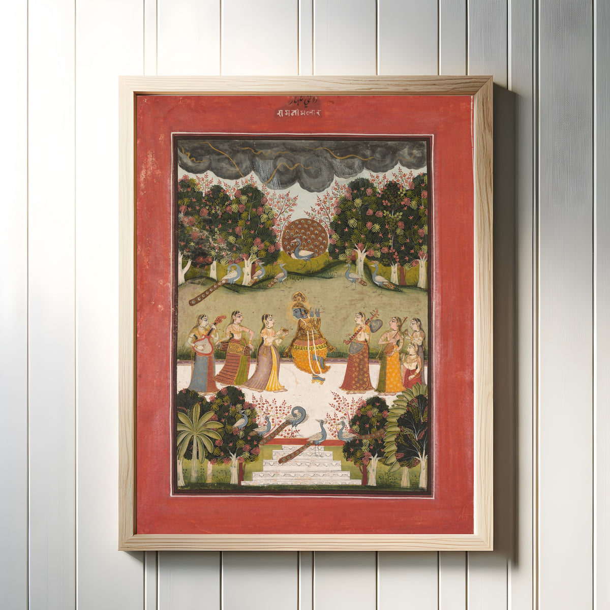 Framed art print of Malar Ragini: Krishna Playing the Flute to Seven Gopis Holding… by Bundi or Kota school, in a light wood frame on a white panelled wall