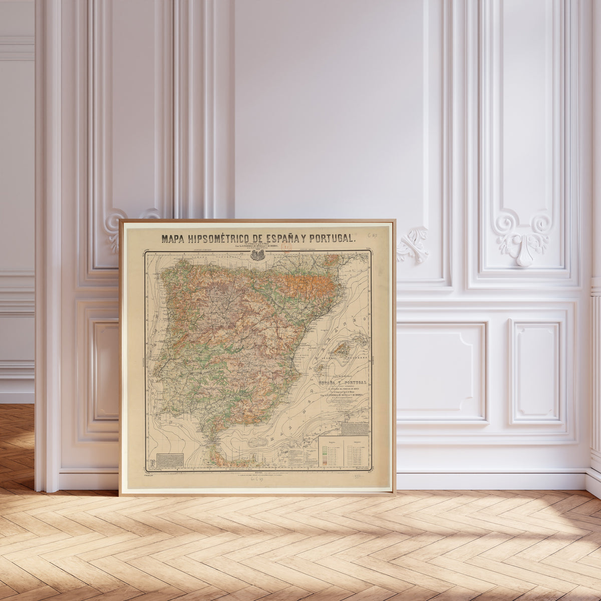 Mapa hipsométrico de España y Portugal by Federico de Botella y de Hornos — framed and leaning against pale pink panelling on a herringbone floor