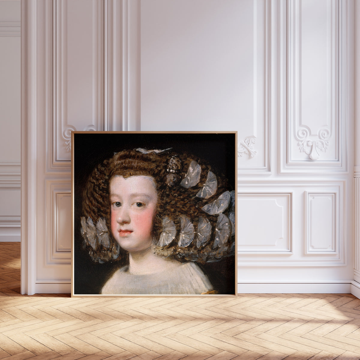 Framed art print of María Teresa, Infanta of Spain by Diego Velázquez, leaning against pale pink panelling on a herringbone floor