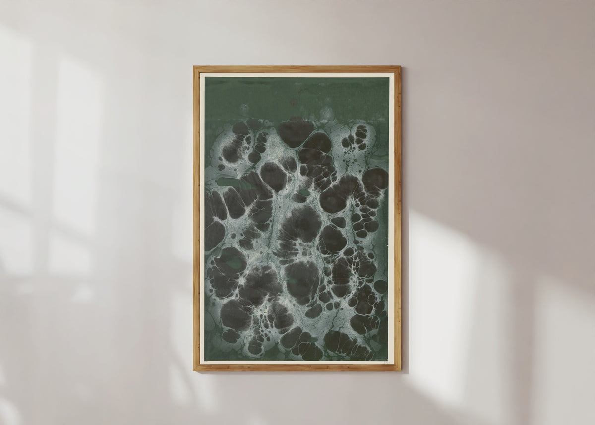 Framed art print of Marmorpapier (black cells on dark green) by Otto Eckmann, in a light wood frame on a sunlit white wall