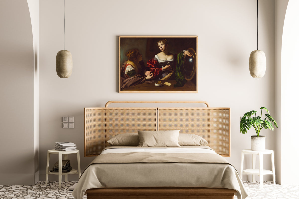 Framed art print of Martha and Mary Magdalene by Caravaggio, above a cane-headboard bed