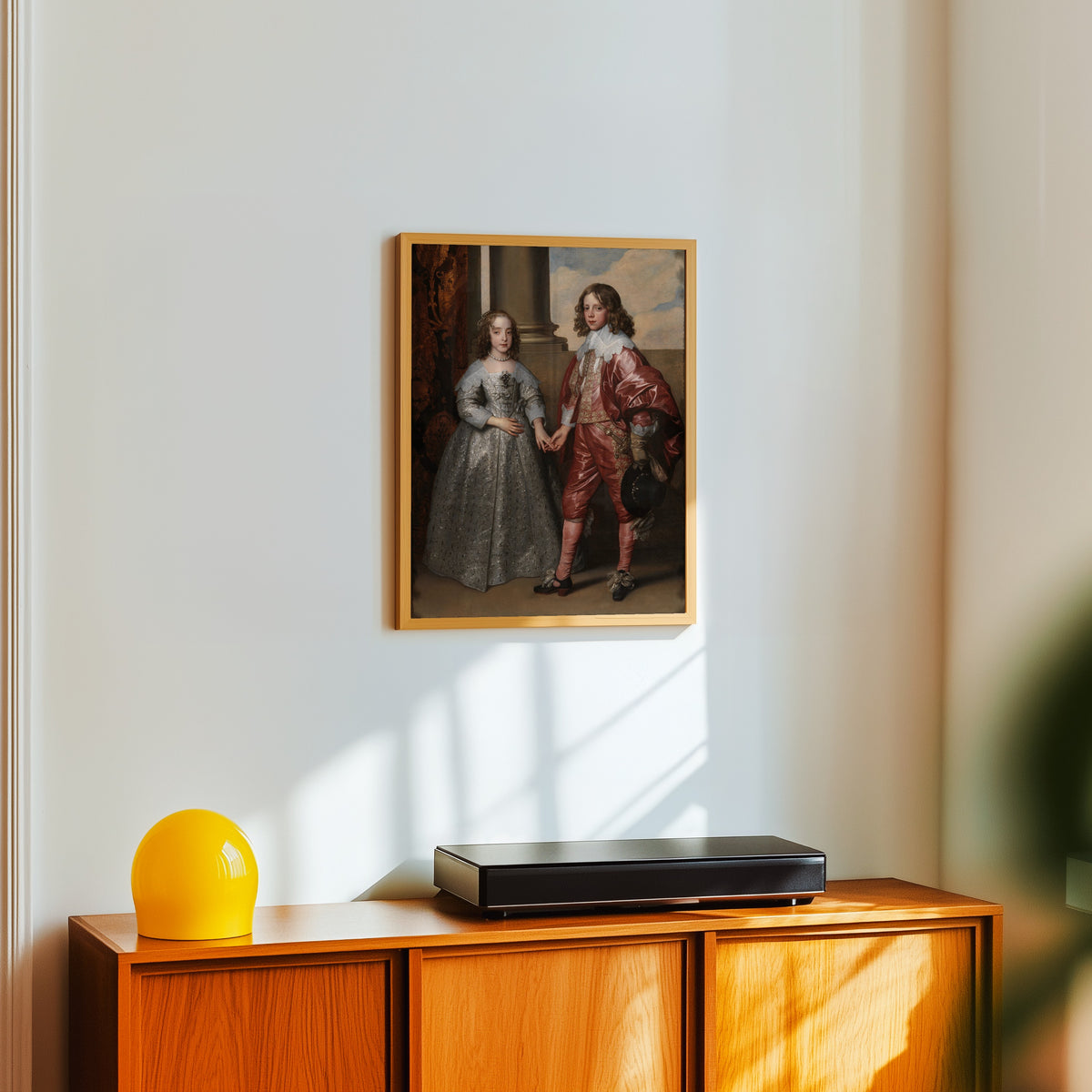 Framed art print of Mary Stuart and William II by Anthony van Dyck, in a light wood frame on a white wall above an orange sideboard