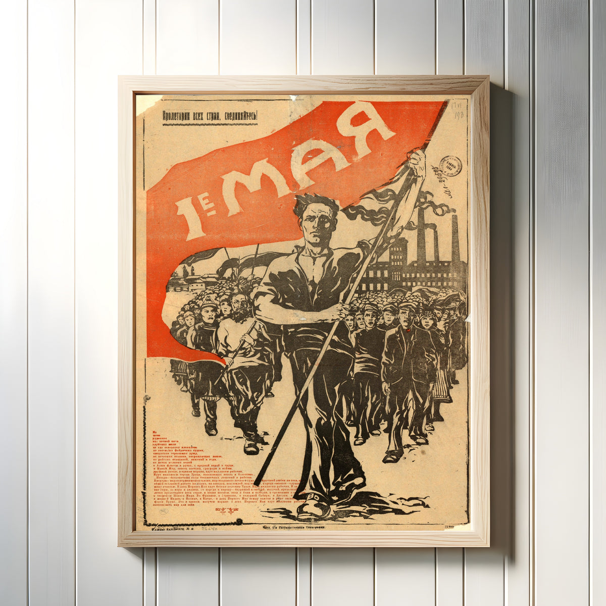 Framed art print of May 1st (the flag-bearer), in a light wood frame on a white panelled wall