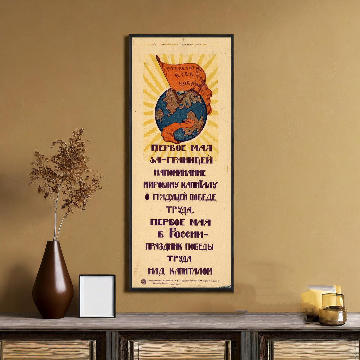 Framed art print of May Day abroad is a reminder to world capital of the coming victory of labour, on an ochre wall above a console table