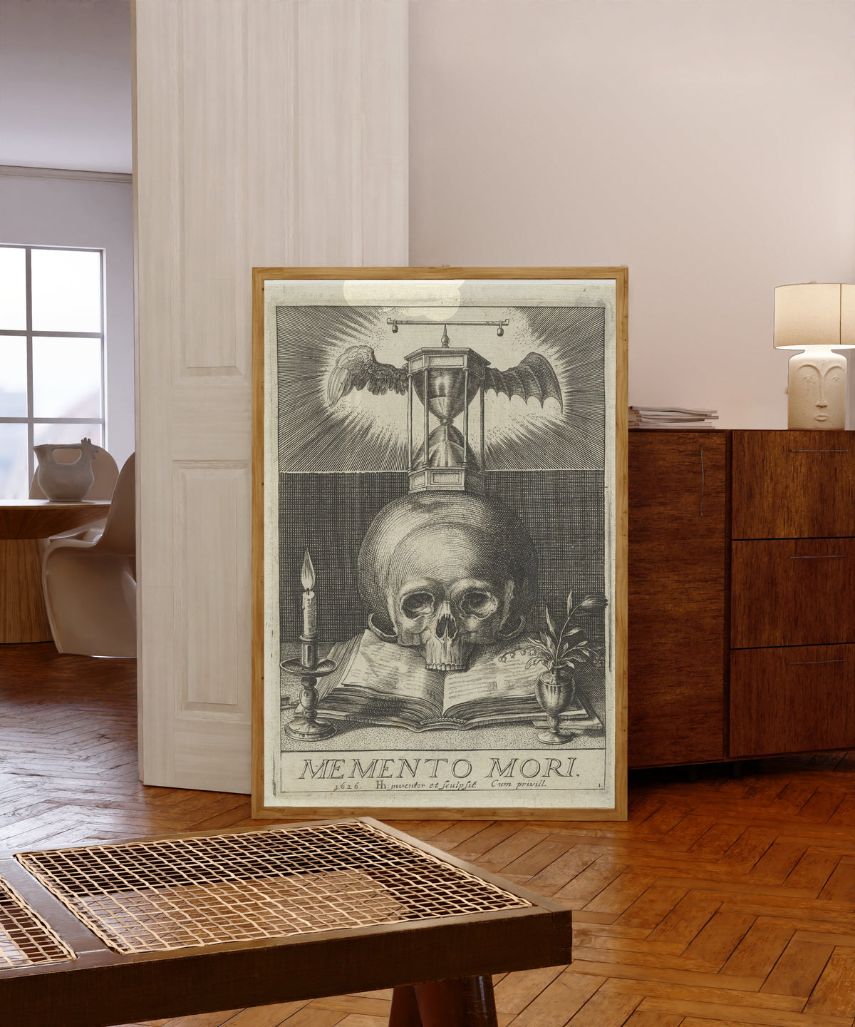 Framed art print of Memento Mori by Hendrick Hondius I, in a light wood frame leaning in a warm room with a parquet floor