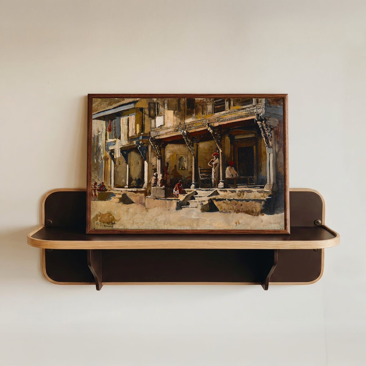 Framed art print of Merchants in Bombay by Edwin Lord Weeks, in a dark wood frame resting on a wall shelf