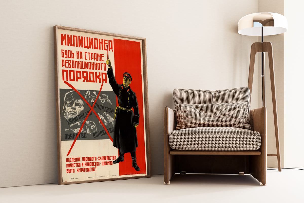 Framed art print of Militiaman, Be on Guard of Revolutionary Order, leaning against a wall beside an armchair and a floor lamp