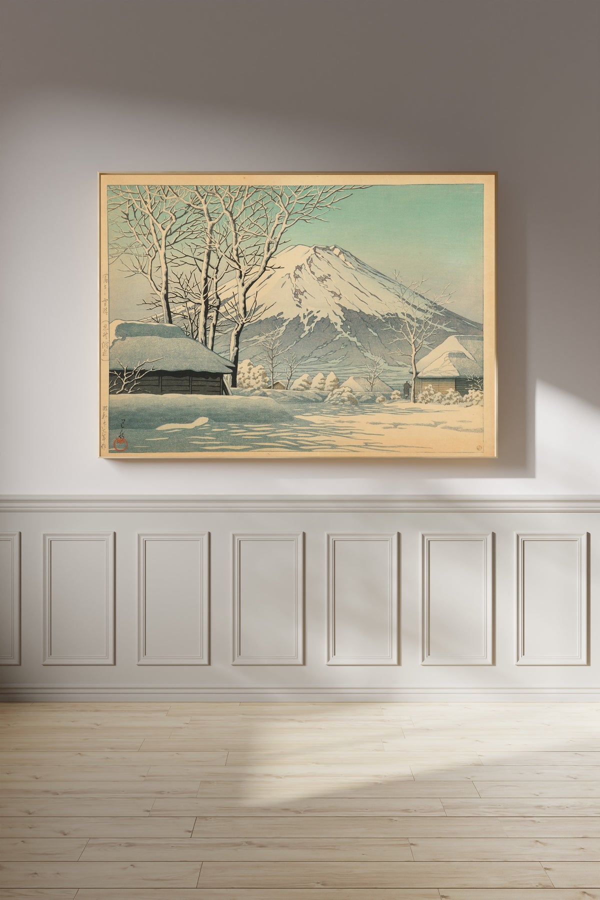 Framed art print of Mount Fuji, Clearing after a Snowfall, Oshino by Kawase Hasui, on a panelled wall in afternoon light
