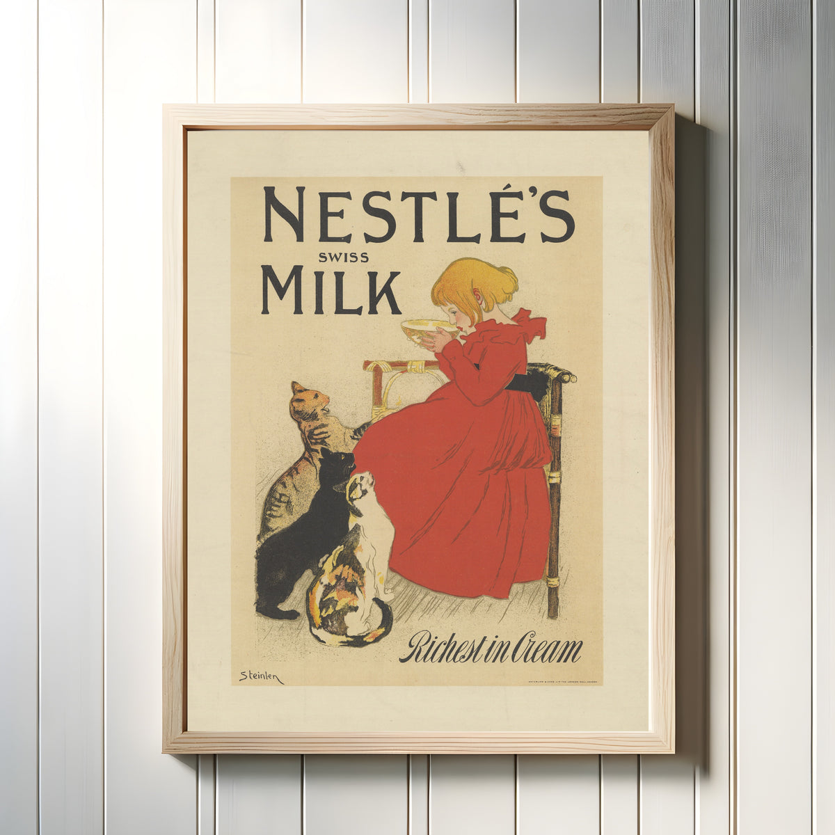 Framed art print of Nestlé’s Swiss Milk, Richest in Cream by Théophile Steinlen, in a light wood frame on a white panelled wall