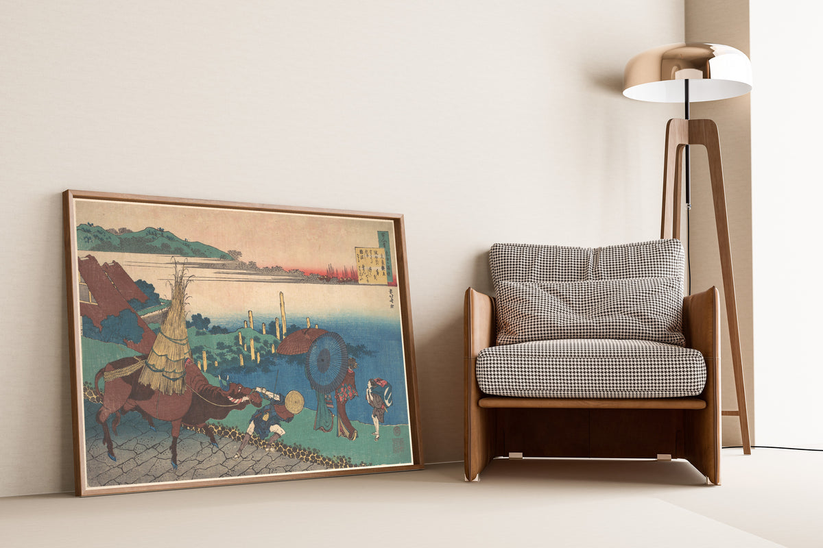 Framed art print of One Hundred Poems Explained by the Nurse: Poem by… by Katsushika Hokusai, leaning against a wall beside an armchair and a floor lamp