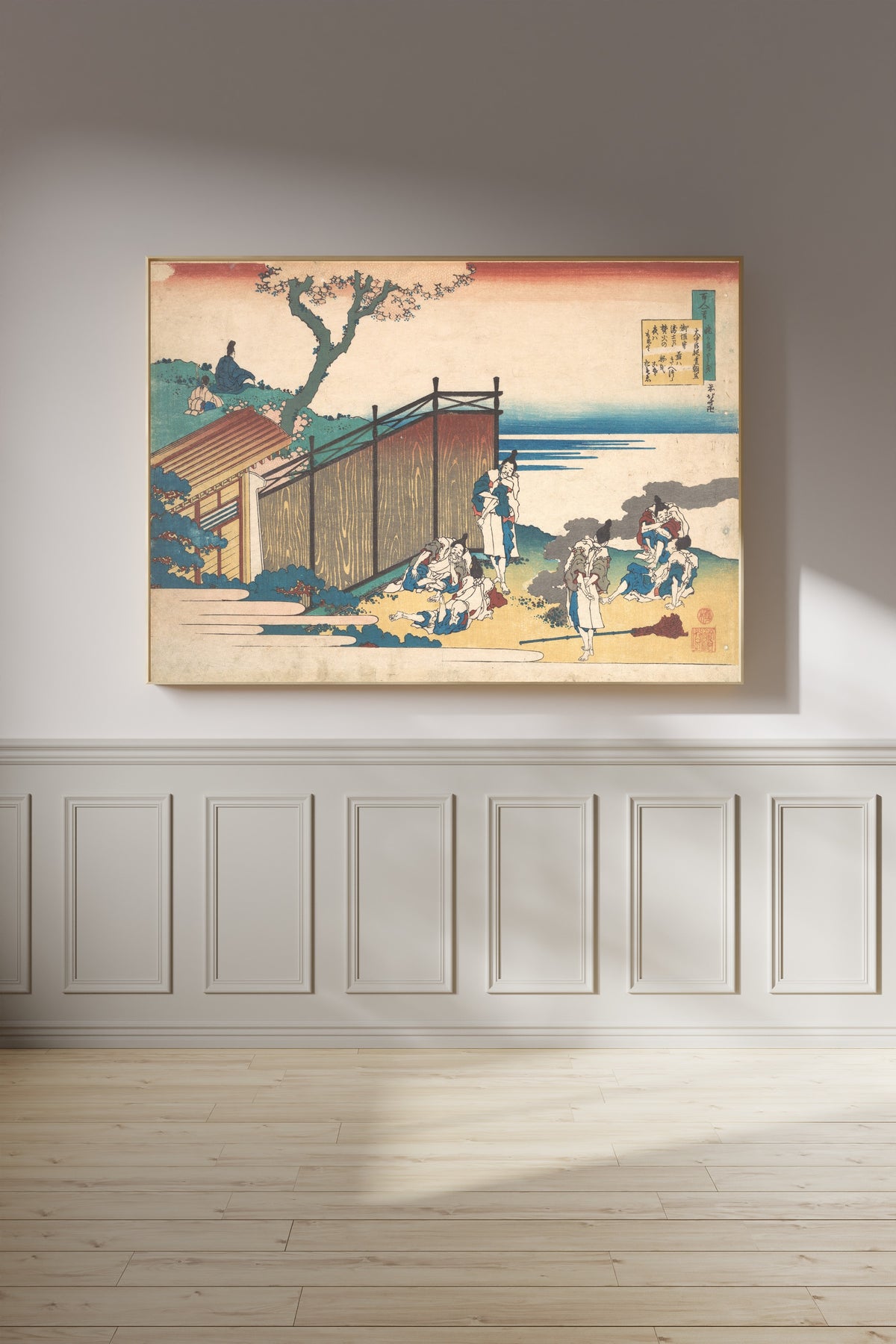 Framed art print of One Hundred Poems Explained by the Nurse: Poem by Ōnakatomi no Yoshinobu Ason by Katsushika Hokusai, on a panelled wall in afternoon light